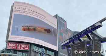 Man buys large billboard in Yonge-Dundas Square to trade single cheese string - Global News