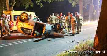 Auto slaat over de kop in Lunteren na botsing tegen boom, omstanders helpen automobilist uit voertuig - De Gelderlander
