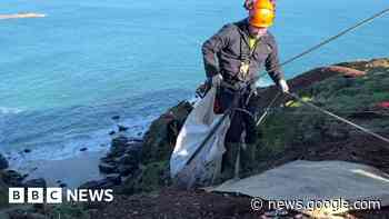Volunteers abseil down cliff for fly-tipped waste in Cornwall - BBC