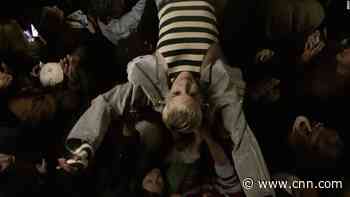 Multiple models fall into the crowd at fashion show