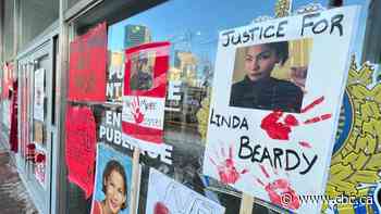 Posters urging action, broken window left at Winnipeg police HQ after rally for woman found dead at landfill