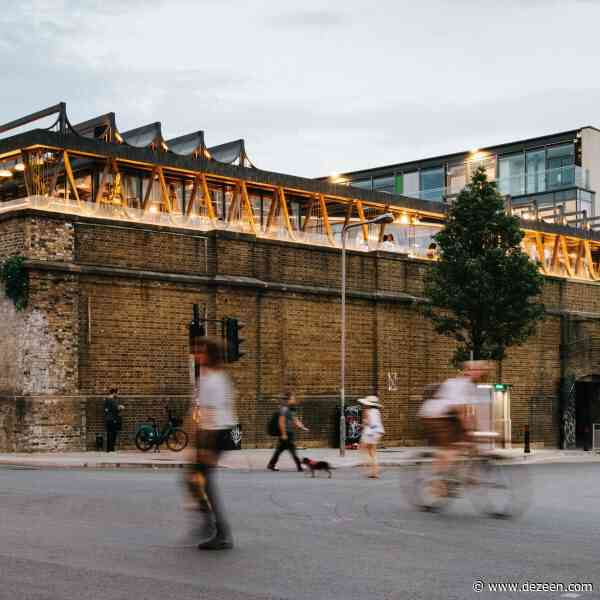 Wavy steel canopy shelters rooftop bar on historic stables in Camden
