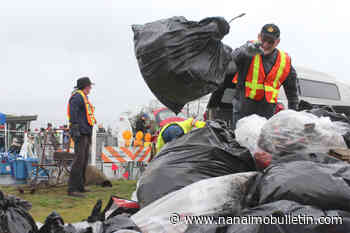 Rotarians from Lantzville and Nanaimo toss trash to the heap on Earth Day