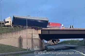Lorry left hanging above A14 road after crashing into bridge barrier
