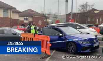 Car sprayed with bullets outside hospital as A&E 'locked down' after man shot nearby