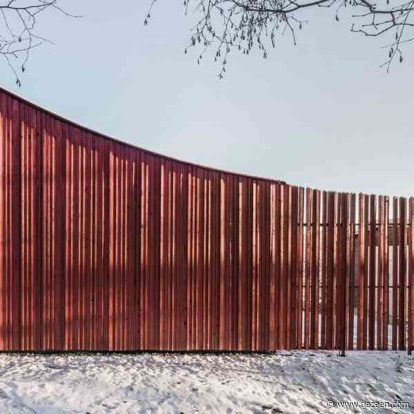 Byró Architekti adds red cabin with sweeping roof to Czech mountainside