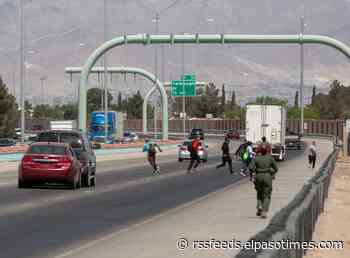 Migrants dangerously run across Border Highway after crossing the border wall in El Paso