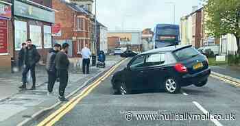 Driver trapped as sinkhole opens up in road
