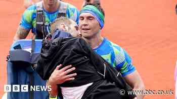 Kevin Sinfield carries Rob Burrow over Leeds marathon finish