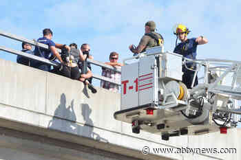 VIDEO: Woman hanging from Langley overpass railing rescued