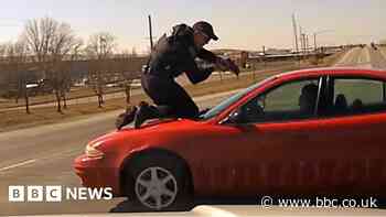 Watch: Officer clings to roof in wild car chase