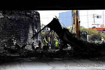 Rescue workers pull body from wreckage of the truck fire under an I-95 overpass in Philadelphia