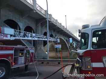 Fire at abandoned encampment under University Bridge under control, but not fully extinguished