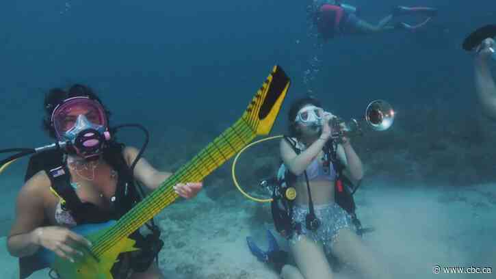 Divers jam underwater to promote coral reef preservation