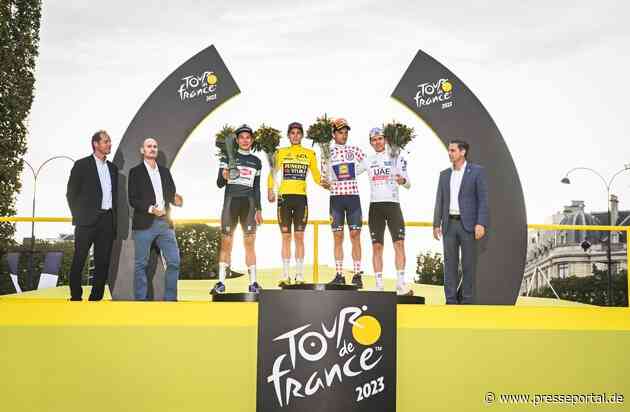 Tour de France-Sieger rollt in Begleitung des noch getarnten Škoda Superb Combi ins Ziel und erhält von Škoda Design entworfene Trophäe