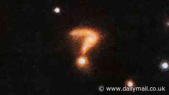 Is anyone out there? Astronomers spot a spooky looking QUESTION MARK hiding next to a pair of young stars in deep space