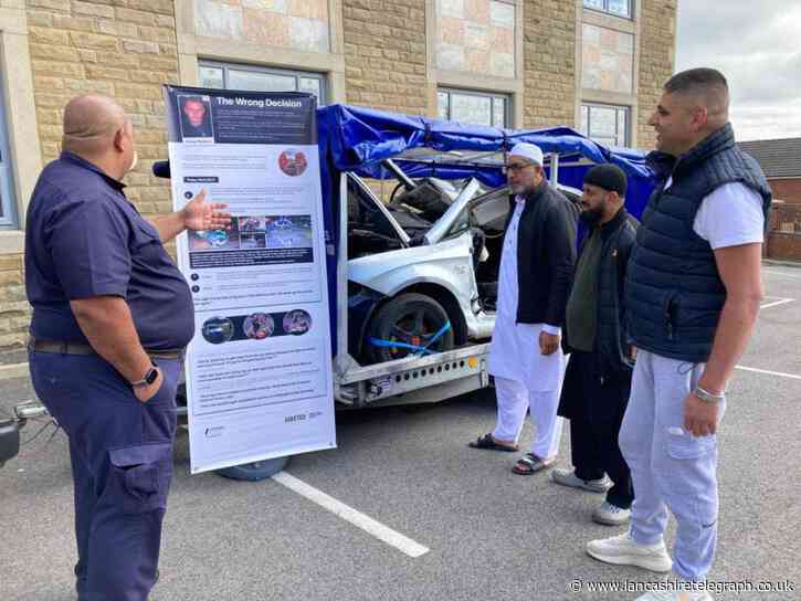 Mosque visitors view crashed car as part of safe driving campaign