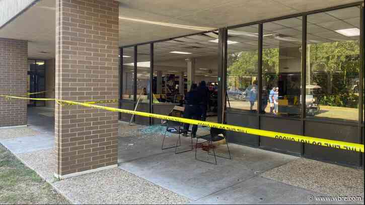 Southern University employees cleaning up glass after golf cart drives through dining hall window