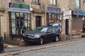 Car left wedged into front of Darwen businesses after crash