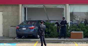 Car crashes into south Edmonton bank, pins man sitting at desk inside
