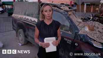 Debris surrounds reporter outside partially collapsed mosque