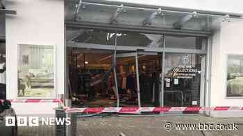 Car crashes through Next store