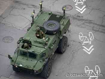 Canadian military armoured vehicle and truck in the midst of Gaza protest in Montreal