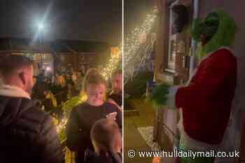 Trick or treaters queue down the street to meet The Grinch who won Halloween