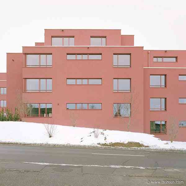 Ductus coats blocky apartment complex with red plaster in Switzerland