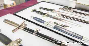 Verzamelaars boden op een beurs SS-dolken met hakenkruizen aan