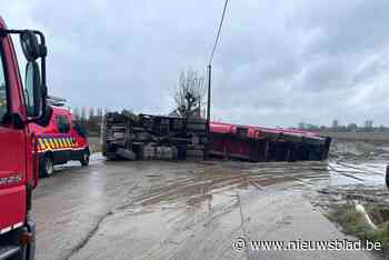Vrachtwagen met aarde kantelt in gracht