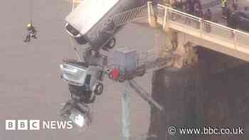 Moment driver is rescued from dangling truck