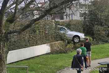 Auto rijdt door struiken op parking van ziekenhuis en zit klem op kleine talud
