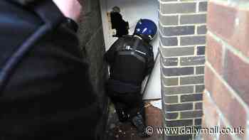 Moment Home Office cops kick down door in dawn raid to smash 'sophisticated' people-smuggling gang who smuggled up to 50 illegal migrants into UK and charged £1,000 a time for fake passports