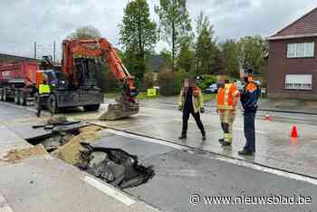Vrachtwagen zakt door wegdek: kraan moet truck uit put lostrekken