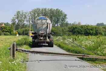 Tractor trekt elektriciteitsdraden en -paal omver
