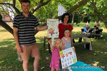 Jonge gezinnen verzamelen aan tuttenboom voor picknick