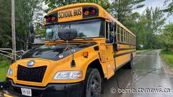 School bus with students onboard becomes entangled in overhead lines