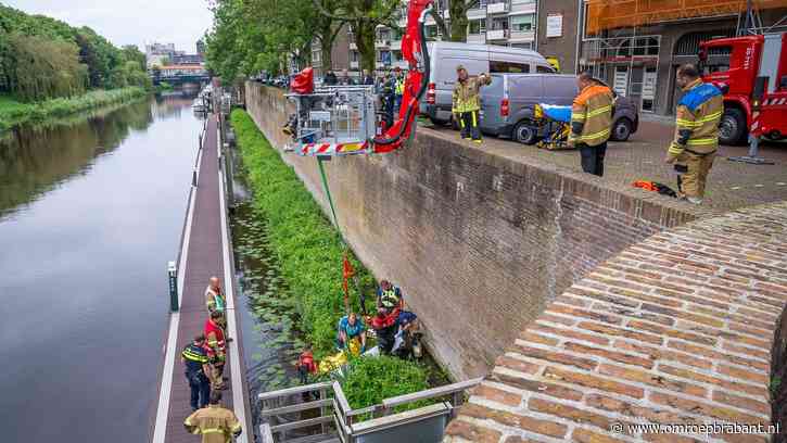 Hoogwerker hijst man uit het water naast metershoge kademuur