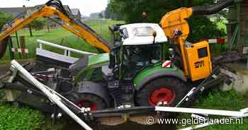 Trekker die bezig was met maaiwerk zakt door fietsbrug