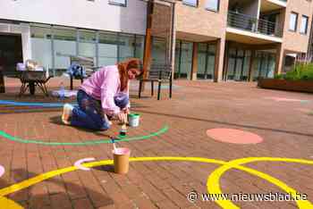Kunstenares Eva zet de bloemetjes buiten op oude stadhuis van Bilzen