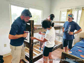 Volunteers build beds for keiki