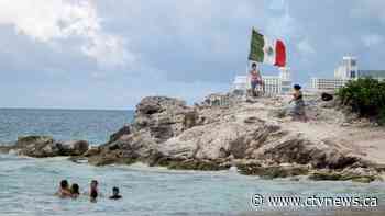 Gunmen on jet skis open fire at rival drug dealer at a beach in Cancun, killing a 12-year-old boy