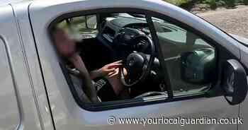 Man trimming his beard while driving on a motorway