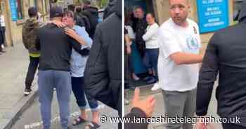 Pubgoers embrace and shake hands with demonstrators on march through town