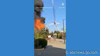 WATCH:  Fire brings down construction crane as bystanders watch on in shock