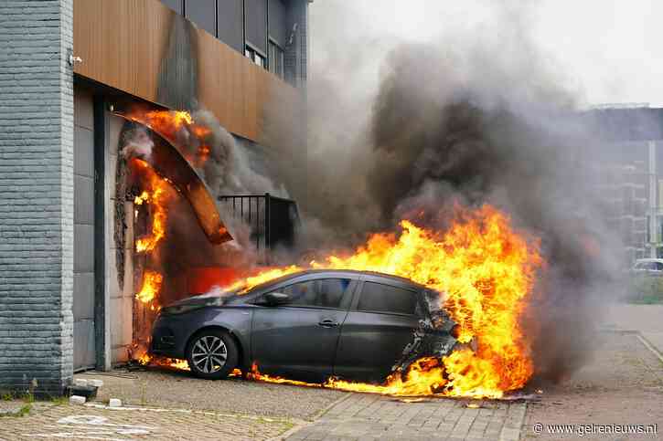 Elektrische auto vliegt in brand tijdens opladen, vlammen slaan over naar bedrijfspand