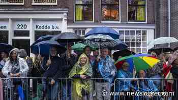 Publiek in poncho's en met paraplu's bij Prinsengrachtconcert