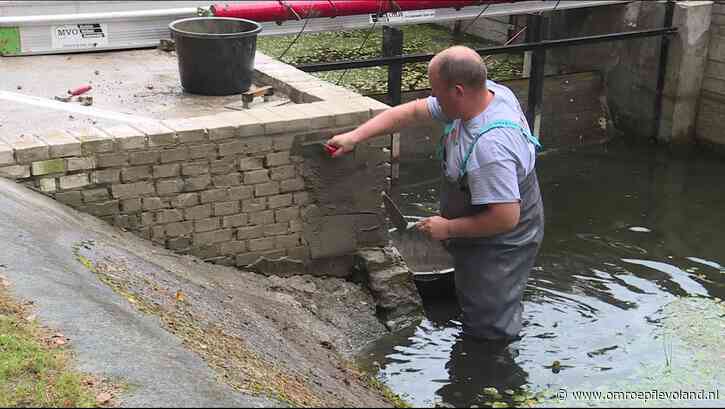 Marknesse - Bouwvakkers tot hun knieën in het water om monument in Waterloopbos te stucen