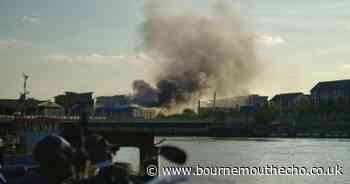 Smoke plumes into sky after derelict building catches fire